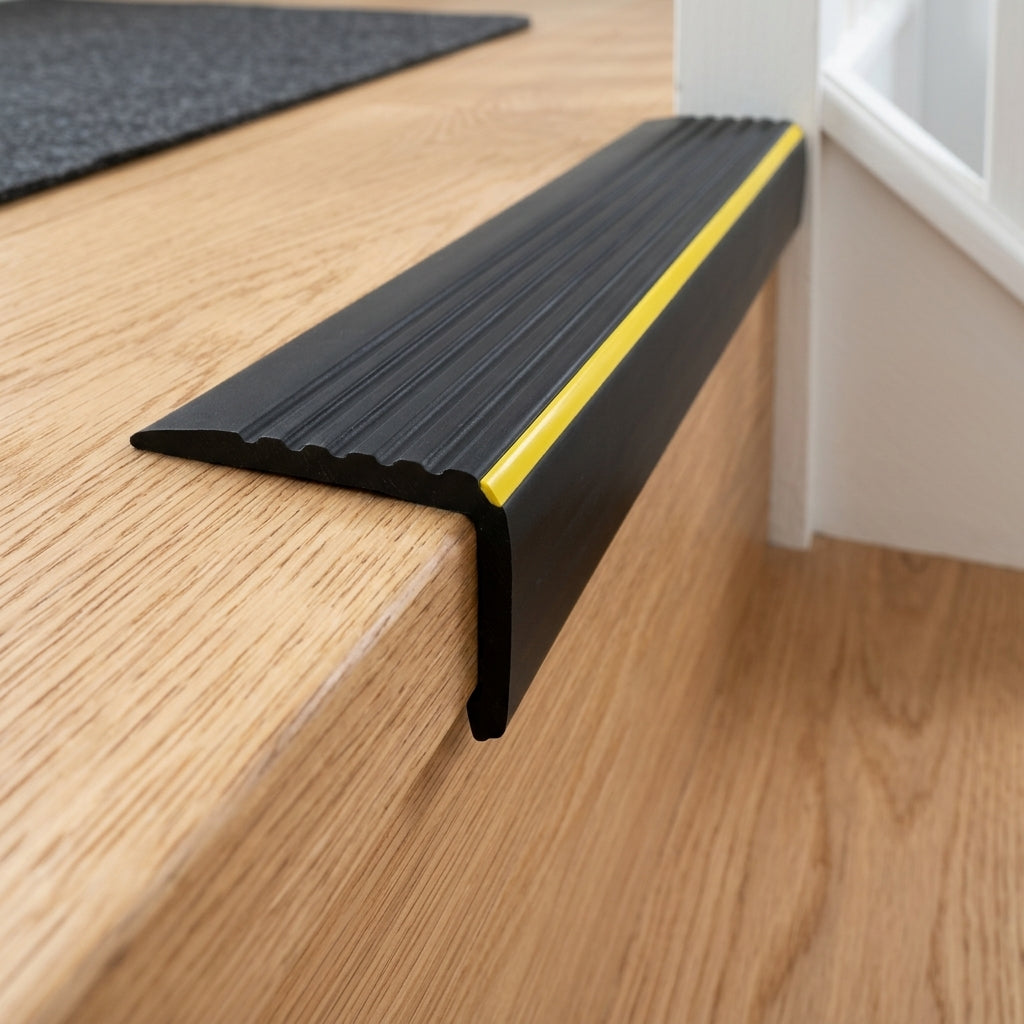 Black non-slip PVC stair nosing with warning strip, 40 x 40 mm – close-up of the yellow warning strip on a stair edge