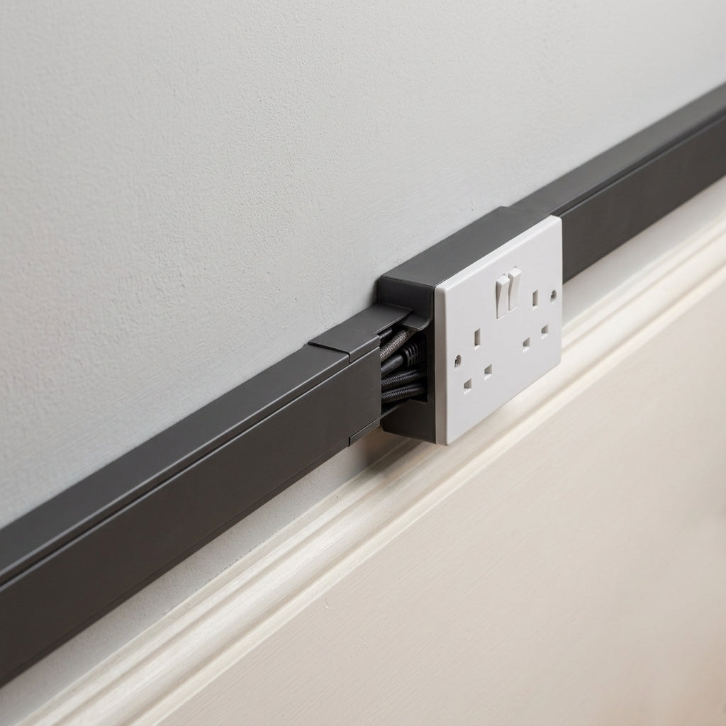 Black mini PVC cable trunking – fitted on a wall leading to a socket